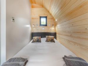 a large white bed in a small room with wooden walls at Rabbits Rest - Uk46128 in Nesscliffe