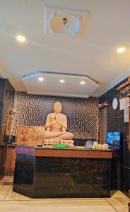 a room with a statue of a buddha on a wall at HoTEL SVR ELITE in Vijayawāda