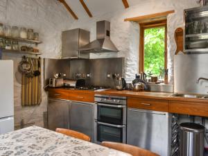 a kitchen with stainless steel appliances and a table at Swallows Barn in Liskeard