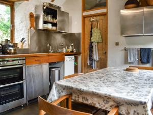 a kitchen with a table with a table cloth on it at Swallows Barn in Liskeard