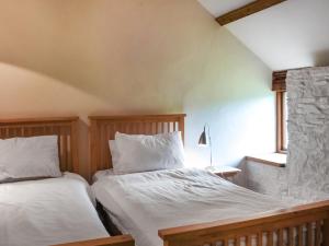 a bedroom with two beds and a window at Swallows Barn in Liskeard +12 photos