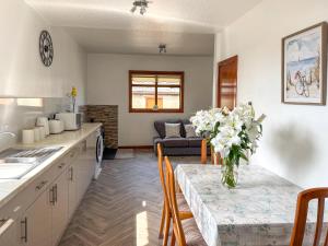 a kitchen with a table with a vase of flowers on it at Maple Cottage in Inverallochy