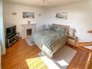 a bedroom with a bed and a fireplace at Maple Cottage in Inverallochy
