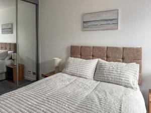 a bedroom with a large bed and a mirror at Maple Cottage in Inverallochy +15 photos