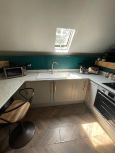 a kitchen with a sink and a stove and a window at Plgs and Blankets in Pucklechurch