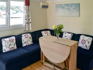 a living room with a blue couch and a table at White Moth - Uk12697 in Stalham