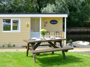 a picnic table in front of a shed at White Moth - Uk12697 in Stalham +3 photos