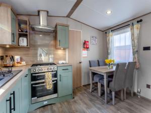 a kitchen with a stove and a table with chairs at The Pines in Aviemore