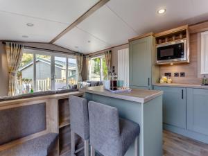 a kitchen with a bar with chairs and a counter top at The Pines in Aviemore