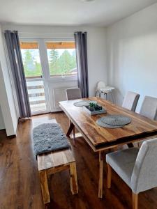 a dining room with a wooden table and chairs at Apartman Glacier in Tatranska Strba