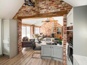 a kitchen and living room with a brick wall at Rose Blossom Cottage in Benniworth