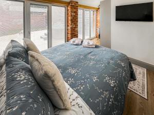 a bedroom with a bed and a large window at Rose Blossom Cottage in Benniworth +11 photos