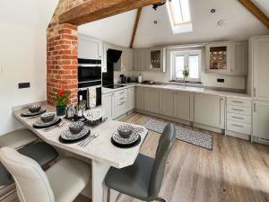 a kitchen with a table and chairs in a room at Rose Blossom Cottage in Benniworth