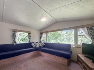 a living room with a blue couch and a tv at Mallard - Uk52121 in Hevingham