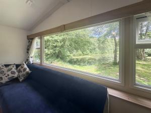 a blue couch in a room with a large window at Mallard - Uk52121 in Hevingham