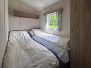 two beds in a small room with a window at Mallard - Uk52121 in Hevingham +4 photos