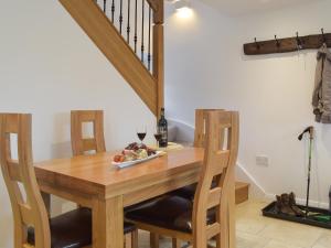 a wooden table with a plate of food and a glass of wine at Five Barred Gate Barn in Inglewhite