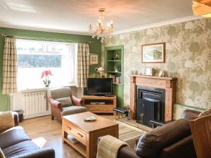 a living room with a couch and a fireplace at Balnowlart Lodge in Ballantrae