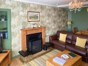 a living room with a couch and a fireplace at Balnowlart Lodge in Ballantrae