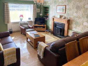 a living room with a couch and a fireplace at Balnowlart Lodge in Ballantrae