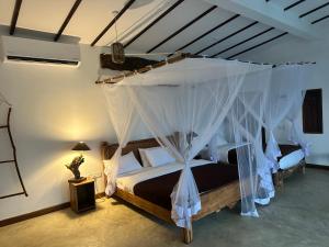 a bedroom with two beds with mosquito nets at Bethel Ella in Ella