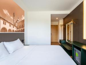 a bedroom with a white bed and a tv at B&B HOTEL Ascoli Piceno in Ascoli Piceno