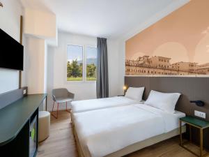 a hotel room with a bed and a tv at B&B HOTEL Ascoli Piceno in Ascoli Piceno