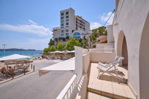 a view of a beach and a building with chairs and tables at INNER Niza Paguera in Paguera