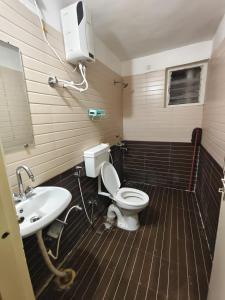 a bathroom with a toilet and a sink at Aura Vista in Bhopal