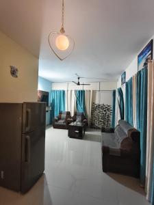 a living room with a couch and a refrigerator at Aura Vista in Bhopal +1 photo