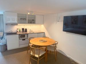 a small kitchen with a wooden table and chairs at Studio Next to CPH Airport with Outdoor Space in Copenhagen