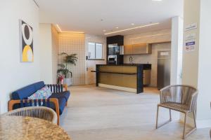 a living room with a blue couch and a kitchen at Apartamento Bitú in Fortaleza