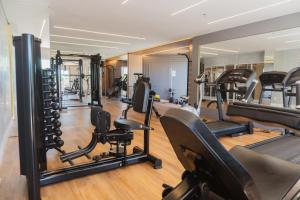 a gym with a lot of treadmills and ellipticals at Apartamento Bitú in Fortaleza
