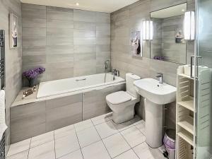 a bathroom with a tub and a toilet and a sink at Valentines Cottage - Uk48509 in Kirk Hammerton