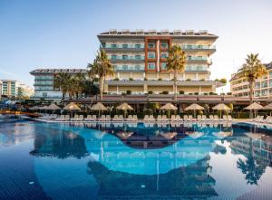 a hotel with a swimming pool in front of a building at Adalya Ocean Deluxe - Ultra All Inclusive in Side