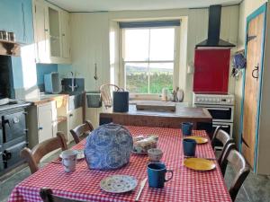 a kitchen with a table with a red table cloth at Downhouse in Delabole
