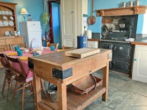 a kitchen with a wooden table with a counter top at Downhouse in Delabole