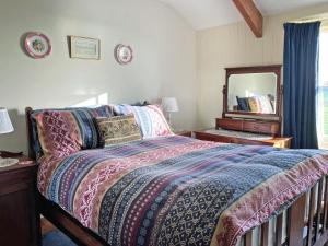a bedroom with a bed and a mirror on the wall at Downhouse in Delabole +27 photos