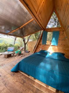 a bedroom in a tree house with a bed at Snawbar glamping in ‘Ibrīn