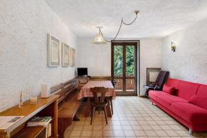 a living room with a red couch and a table at Dolomiti Apartment Pinzolo in Pinzolo