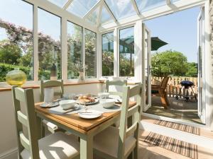 a conservatory dining room with a table and chairs at The Barn - Uk2475 in West Witton