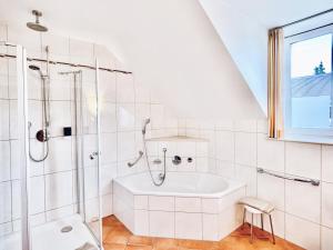 a white bathroom with a shower and a sink at Hotel Kriemhild am Hirschgarten in Munich +84 photos