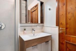 a bathroom with a sink and a mirror at Dolomiti Apartment Pinzolo in Pinzolo +17 photos