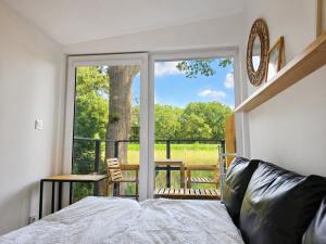 a bedroom with a bed and a large window at Chalet Oslo in Bleckede +7 photos