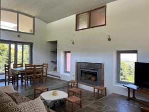 a living room with a fireplace and a table at Seta Forest House in Séta