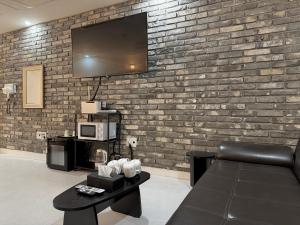 a living room with a tv on a brick wall at Hotel Avenue in Tansa-gol