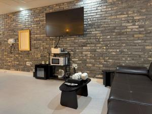 a living room with a couch and a tv on a brick wall at Hotel Avenue in Tansa-gol