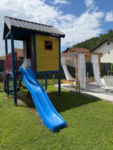 a playground with a slide and a house at Luxury Apartments Sarajevo in Ilijaš