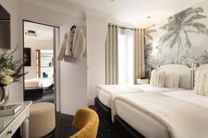 a hotel room with two beds and a mirror at Hotel London in Paris +47 photos