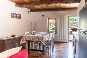 eine Küche und ein Esszimmer mit Tisch und Stühlen in der Unterkunft I Sitoù in Ostana